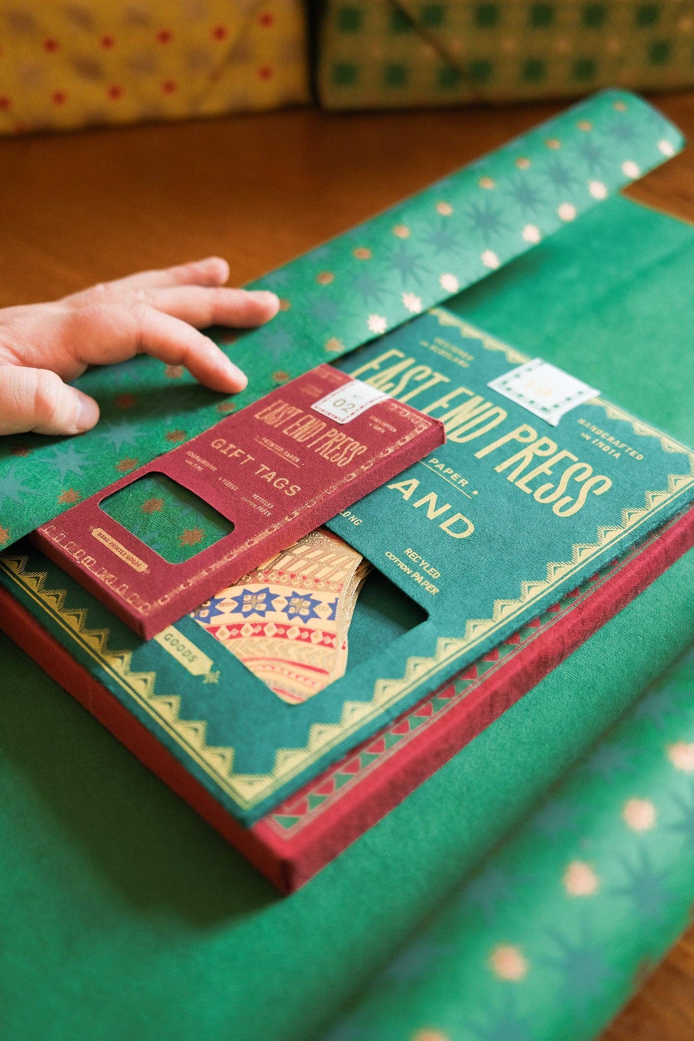 Green box with red label featuring text and graphics, with a hand on top