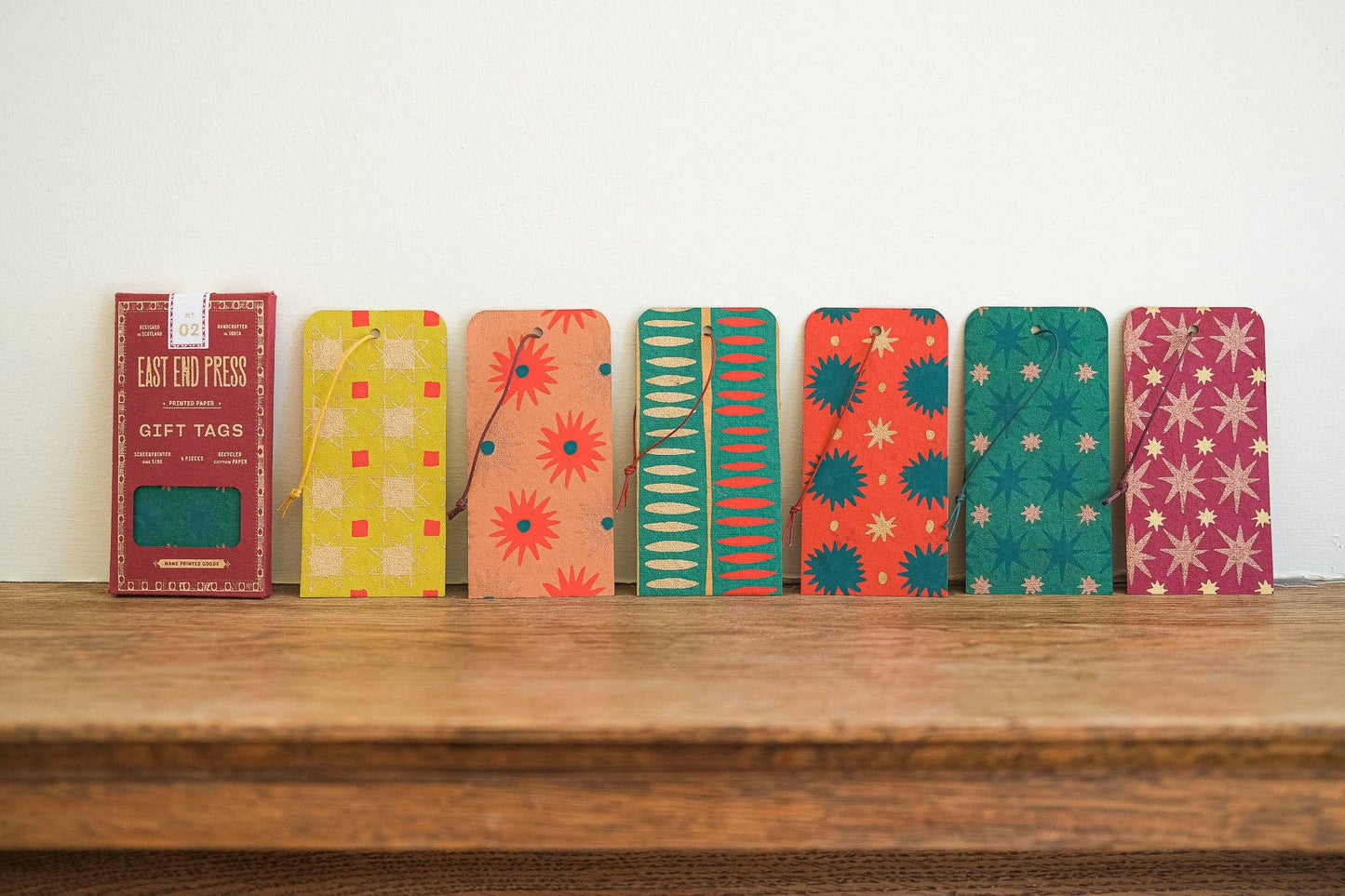 Colorful gift tags on a wooden surface with a white background