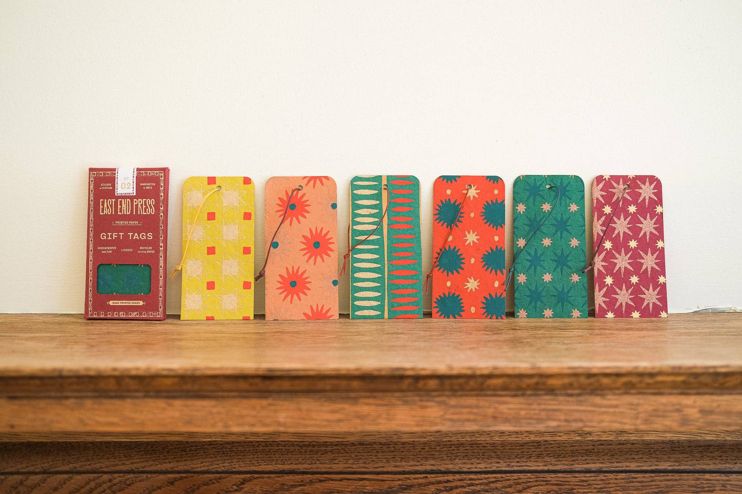 Colorful gift tags on a wooden surface with a white background