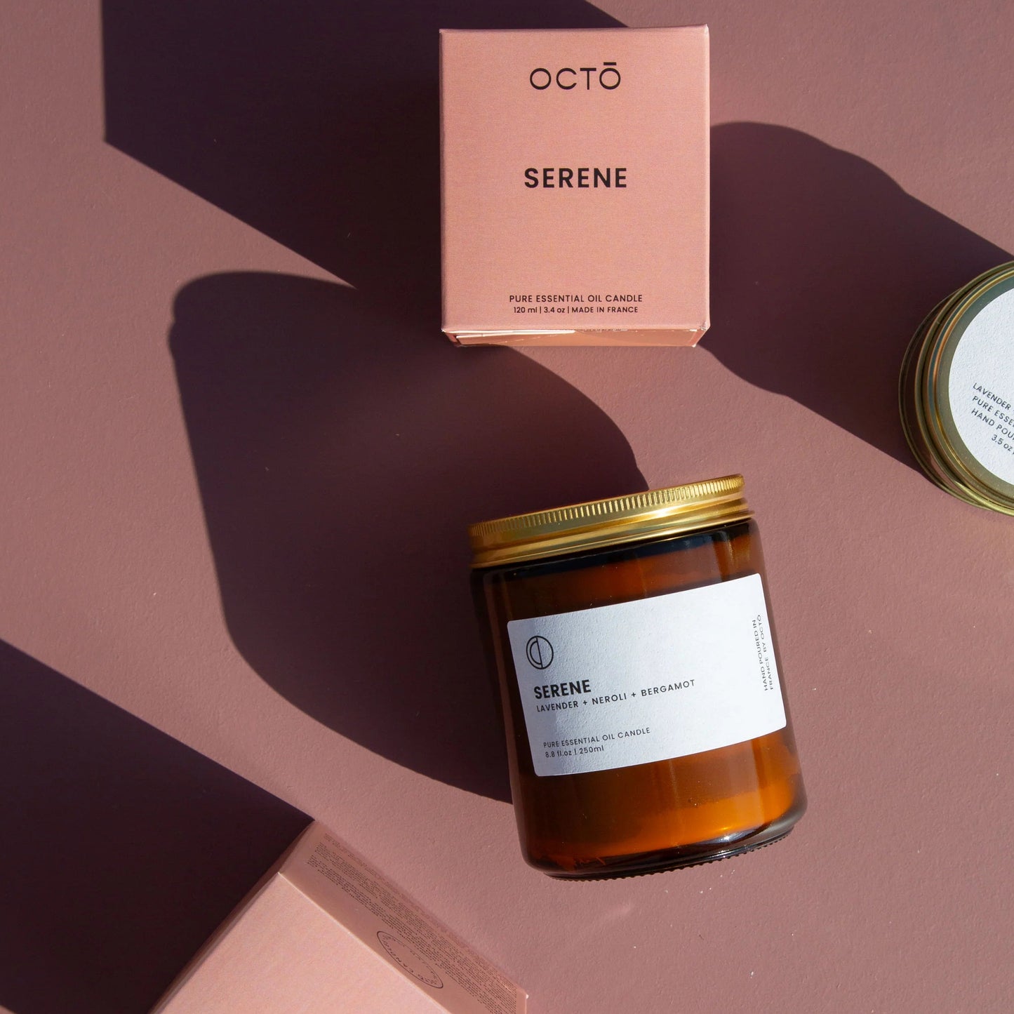 Candle and packaging with 'octó' branding on a pink background