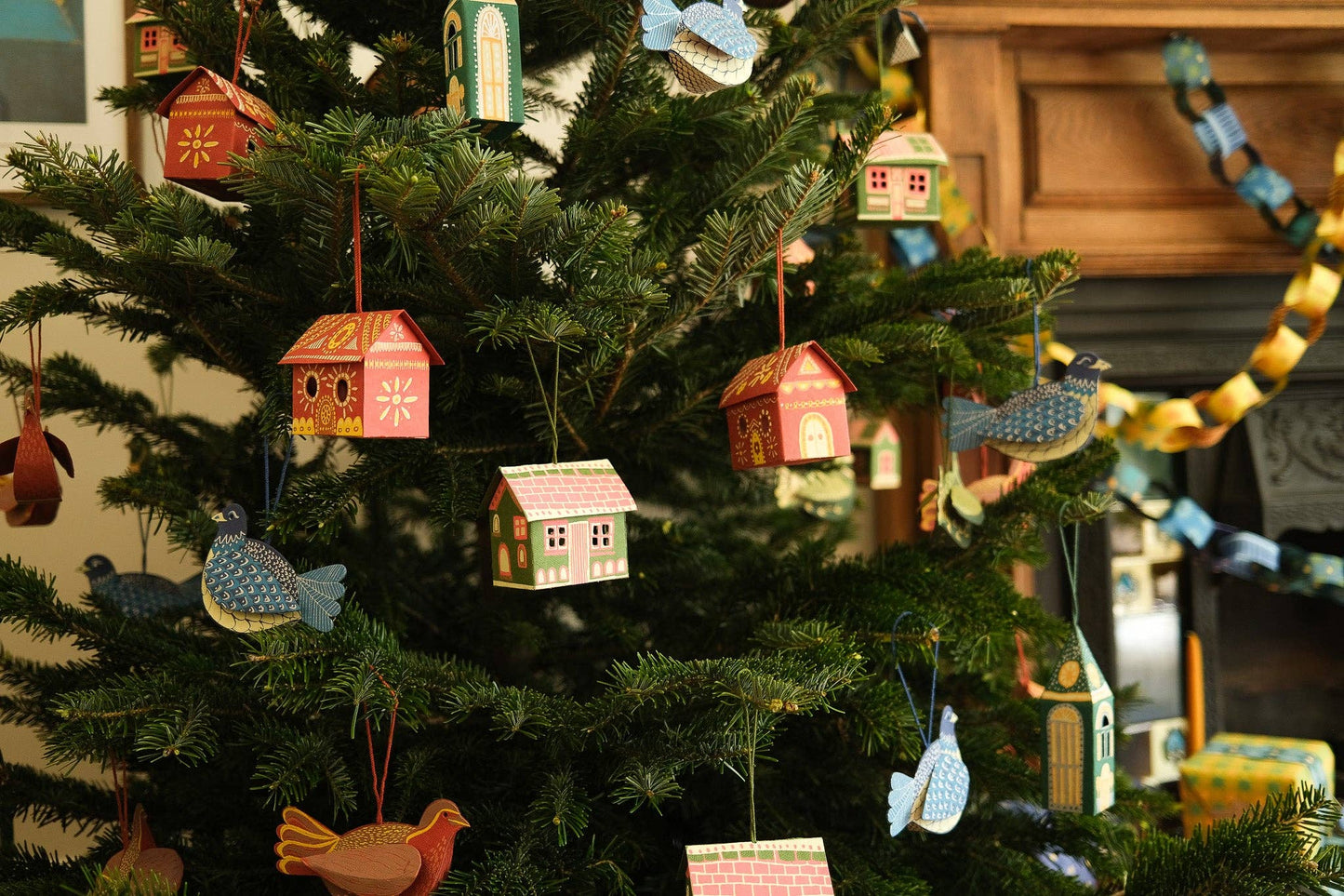 Decorative Christmas tree with small houses and birds ornaments.