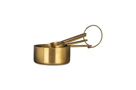 Set of brass measuring cups on a white background
