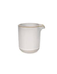 White ceramic pitcher with gold rim on a white background