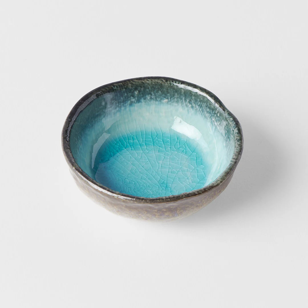 Ceramic bowl with blue interior and black exterior on a white background