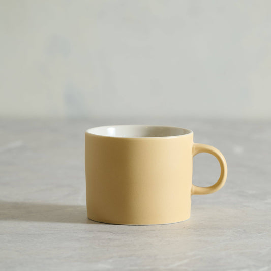 Yellow mug on a light gray background