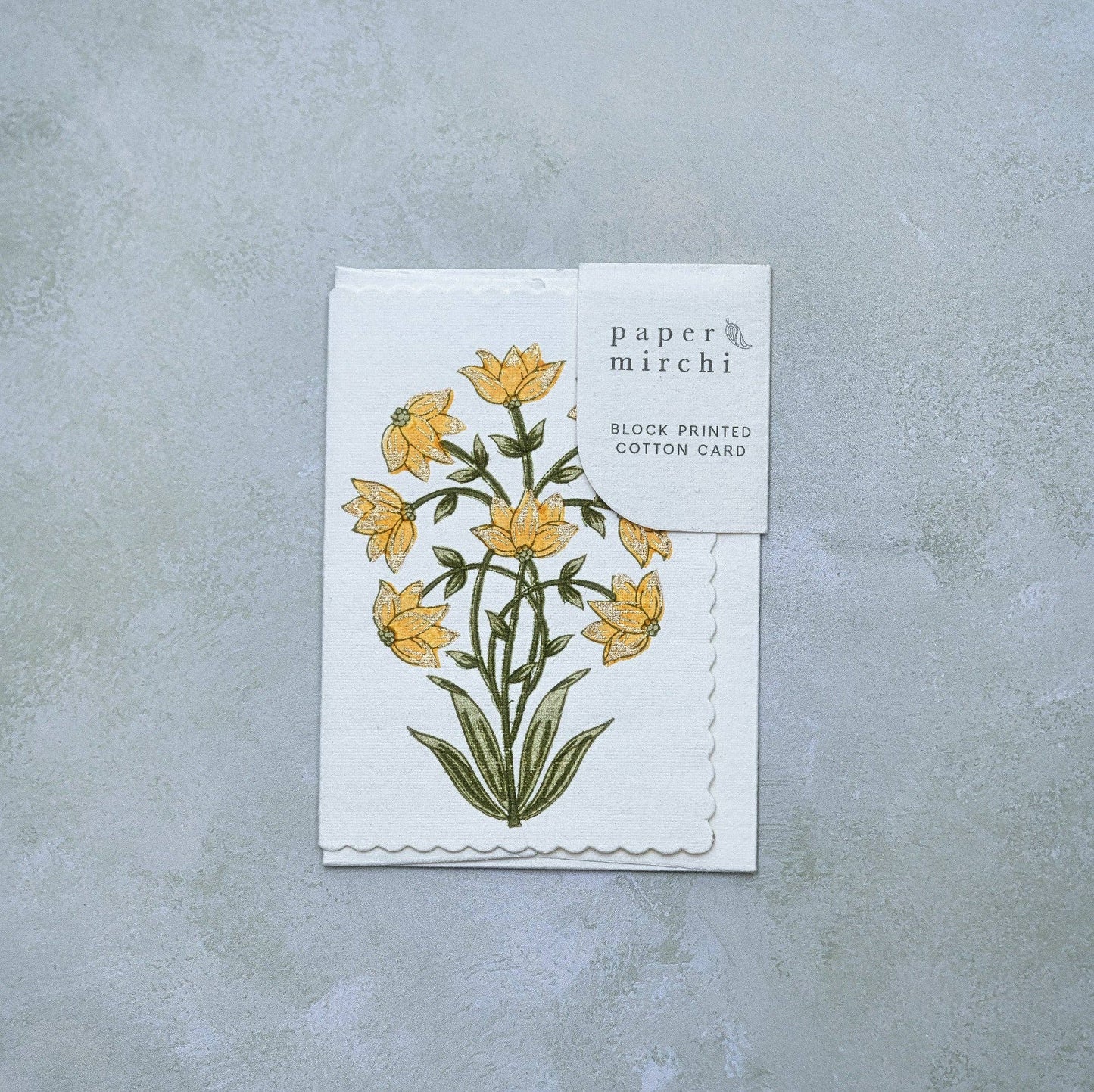 Card with floral design and 'paper mirchi' branding on a gray background