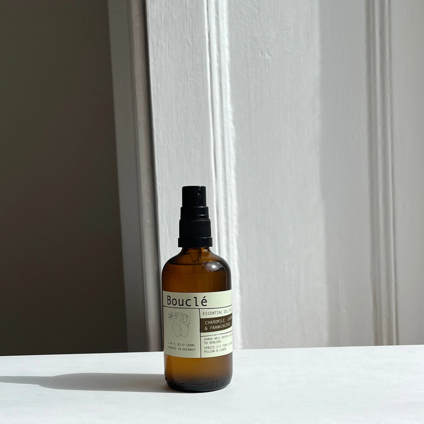Bottle of Bouleé essential oil on a white surface with a neutral background