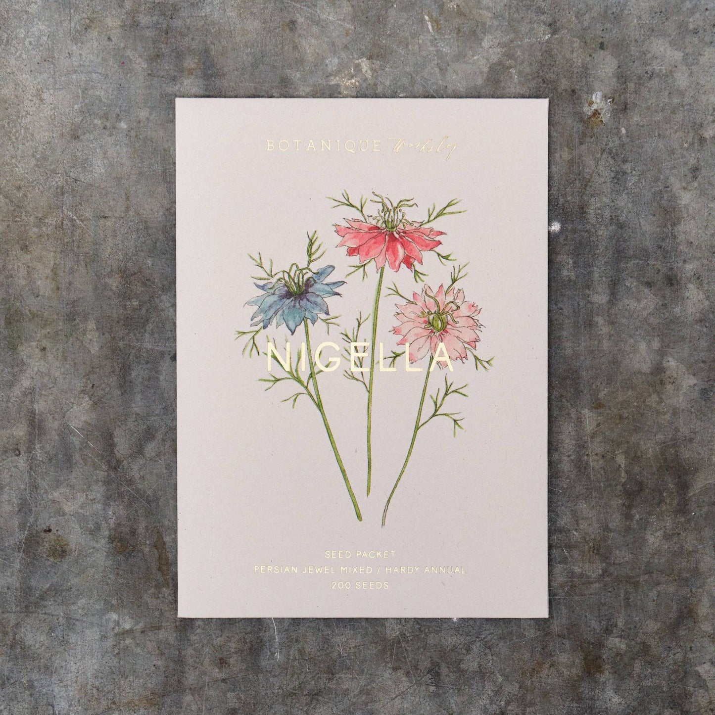 Nigella Seed Packet with floral illustration and text on a textured surface