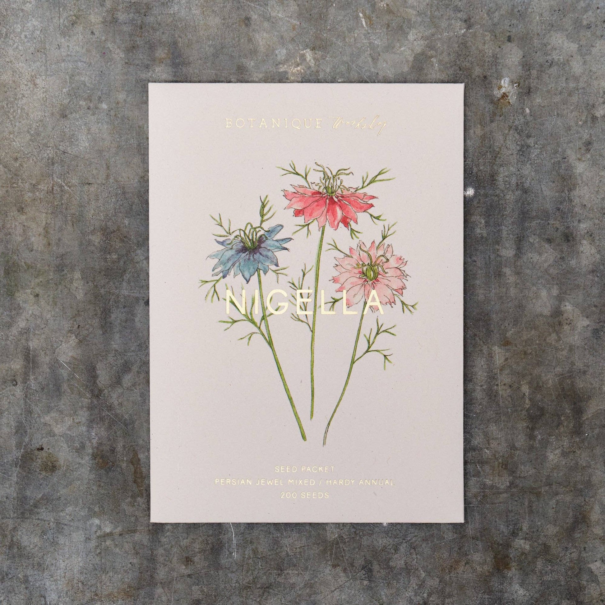 Nigella Seed Packet with floral illustration and text on a textured surface