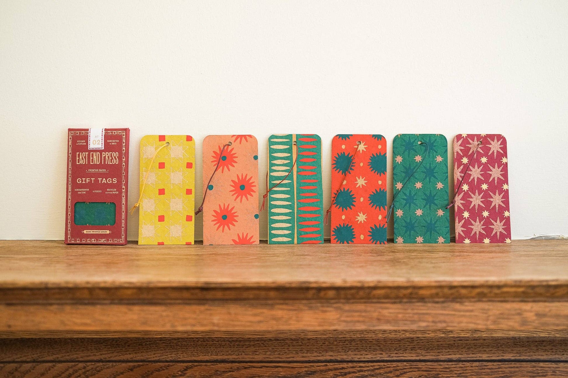 Colorful gift tags on a wooden surface with a white background