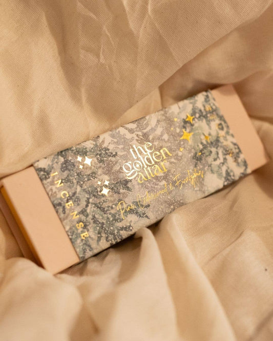 The Golden Altar Incense box with decorative label on a beige fabric background