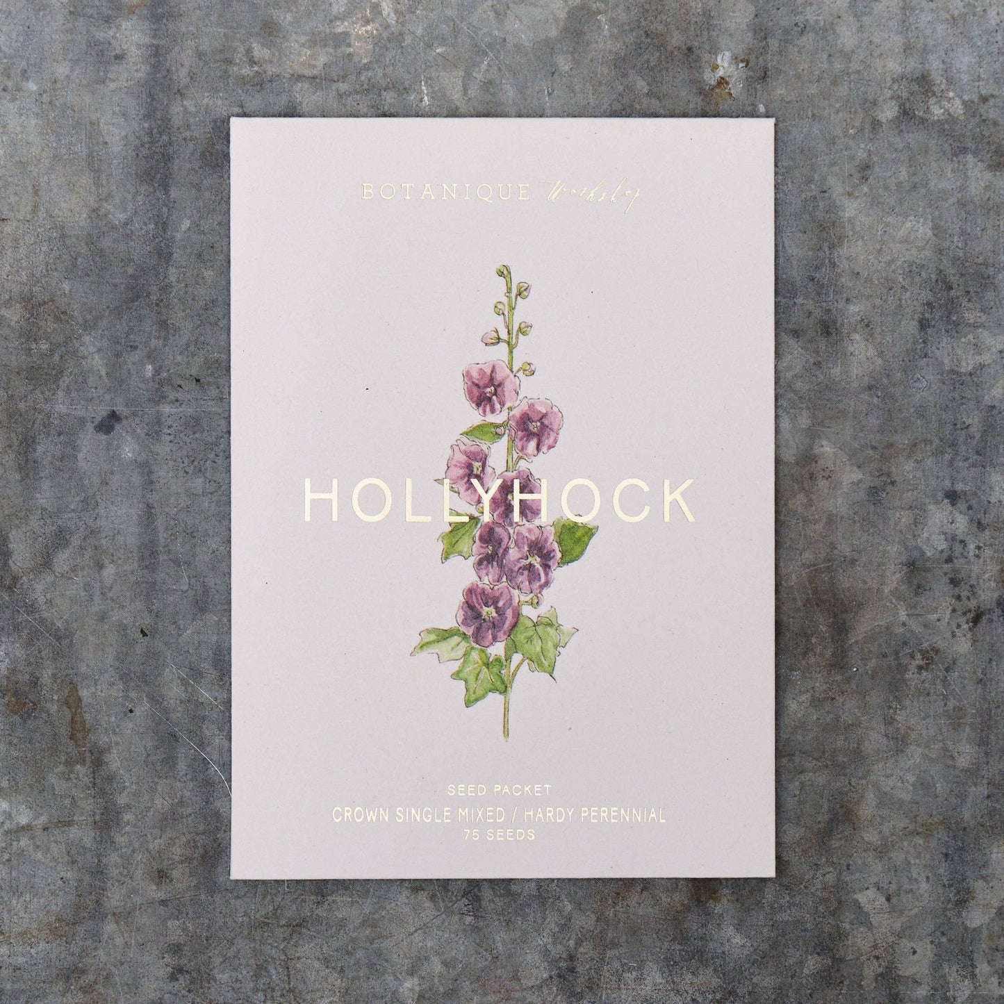 Seed packet with hollyhock illustration on a textured surface