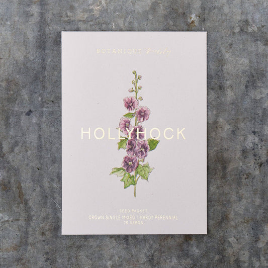 Seed packet with hollyhock illustration on a textured surface