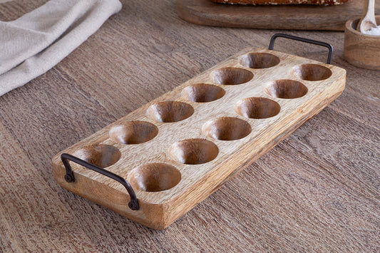 Wooden egg tray with metal handles on a wooden surface