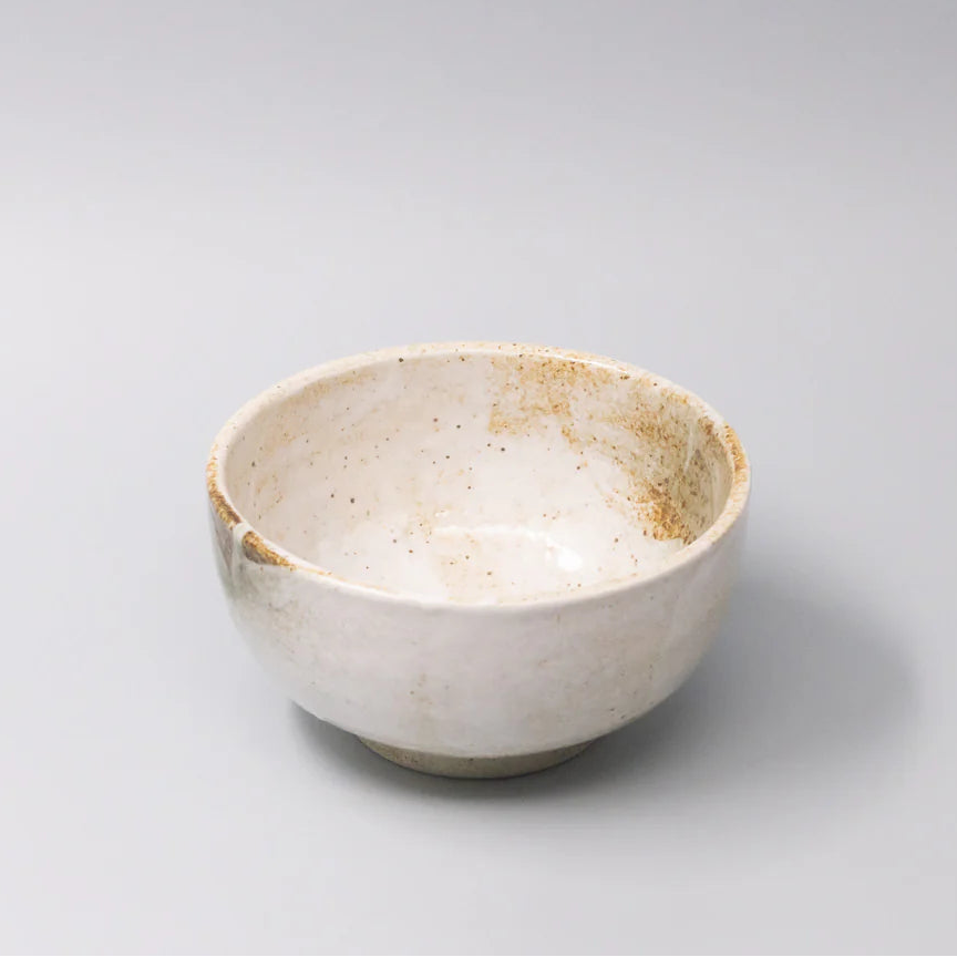 White ceramic bowl with brown accents on a light gray background