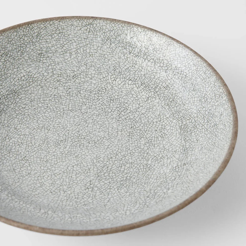 Ceramic plate with a textured surface on a white background. Ceramic bowl with textured surface on a white background. Crazed Grey Shallow Bowl made in Japan 