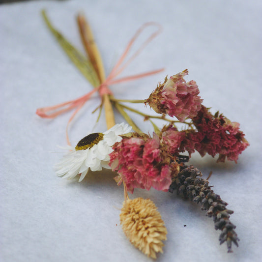 Dried flowers and leaves on a white fabric background