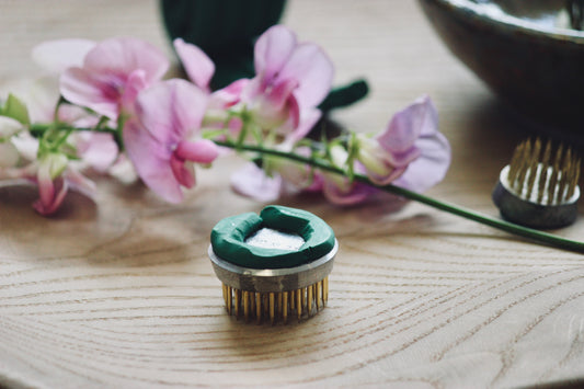 Ensure your floral arrangements stay perfectly in place with this green, water-resistant floral clay. It easily secures flower frogs and pin holders, eliminating tipping and maintaining your display's integrity from creation to completion.