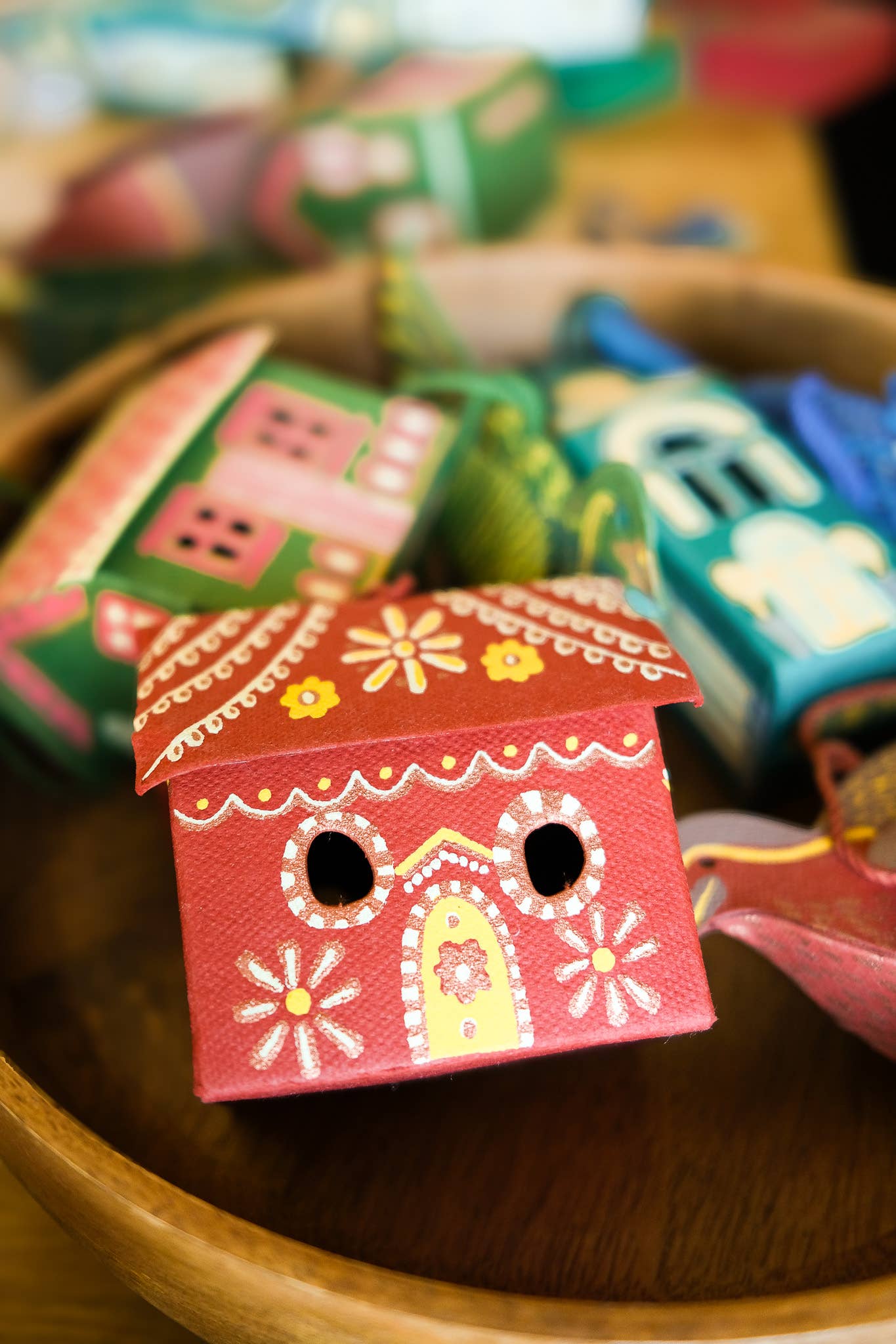 Colorful wooden house-shaped blocks in a wooden bowl