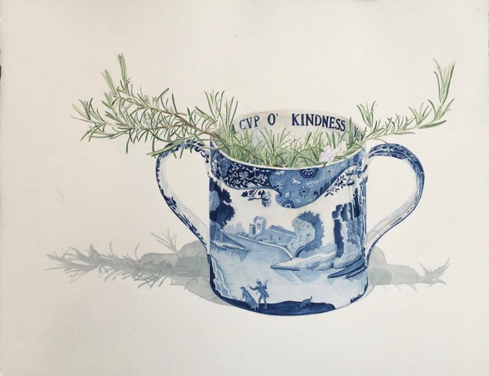 Blue and white ceramic jug with greenery and 'Cup of Kindness' text on a light background