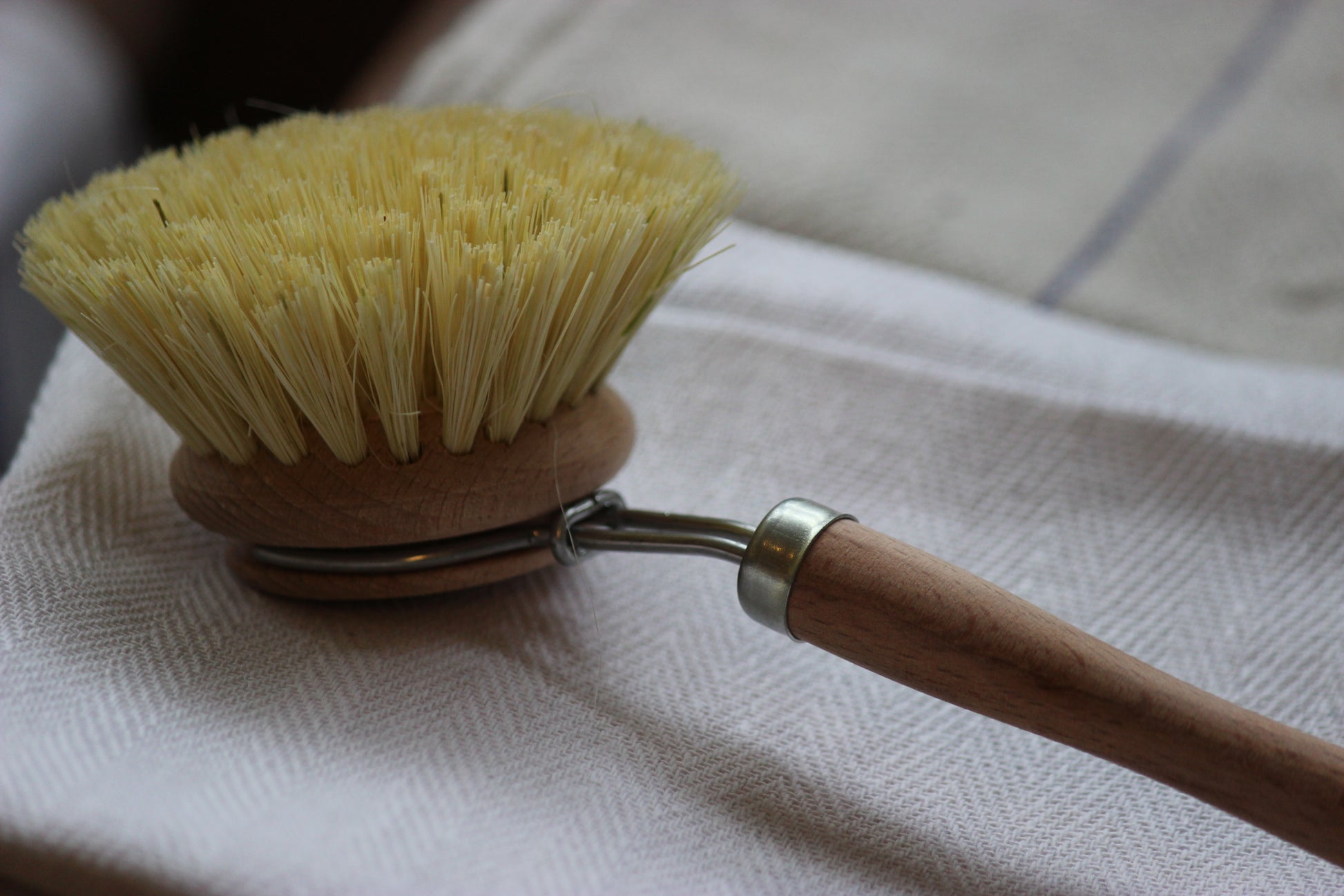 Cleaning brush with wooden handle on a white cloth