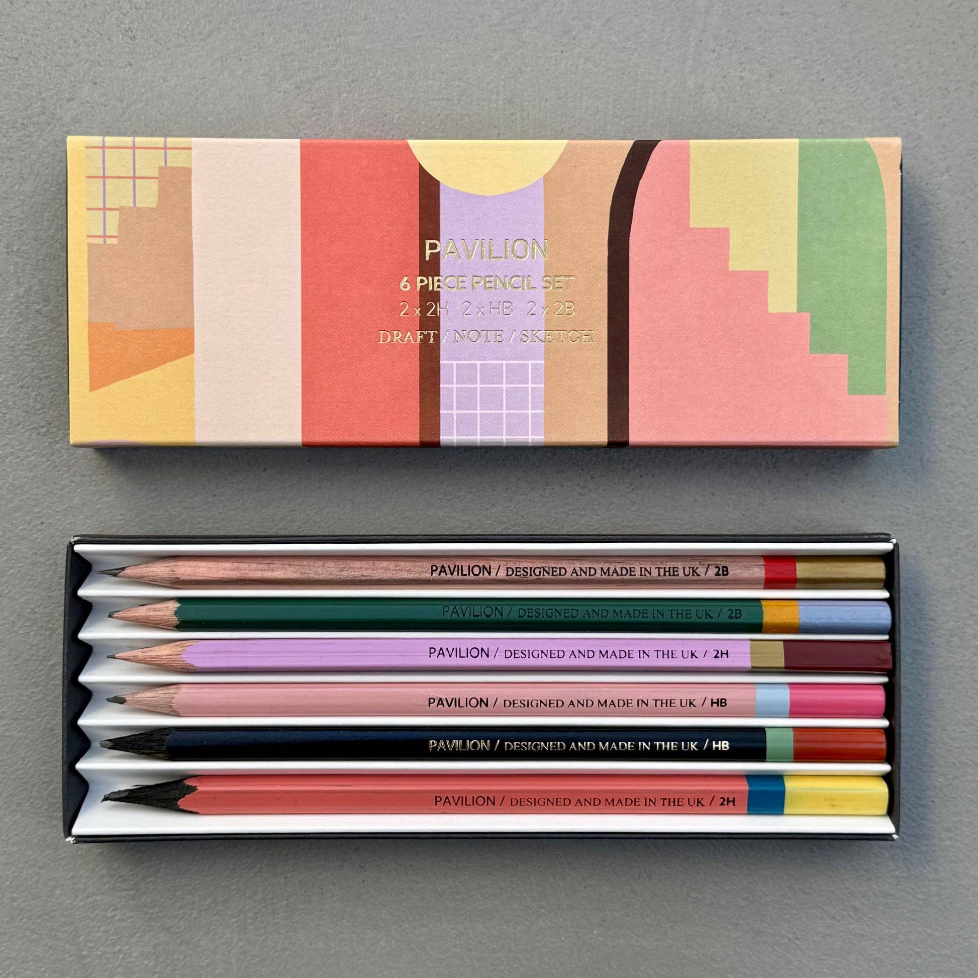 This wonderful 6-piece pencil collection includes 2 square 2H pencils, 2 triangular HB pencils, and 2 hexagonal 2B pencils. Crafted in the UK from sustainably sourced, PEFC-certified wood, each set is presented in a stylish box featuring gold foil accents and a divided tray. Dimensions: 18.5cm x 7cm x 2cm. A perfect gift.