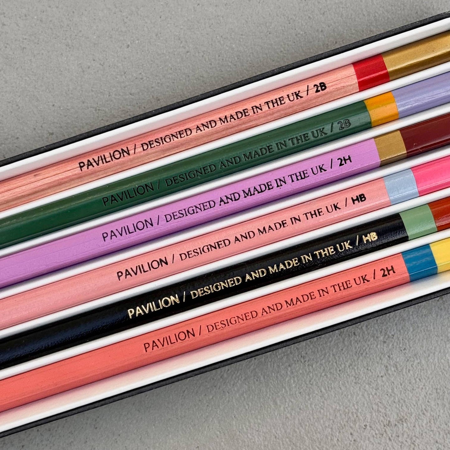 This wonderful 6-piece pencil collection includes 2 square 2H pencils, 2 triangular HB pencils, and 2 hexagonal 2B pencils. Crafted in the UK from sustainably sourced, PEFC-certified wood, each set is presented in a stylish box featuring gold foil accents and a divided tray. Dimensions: 18.5cm x 7cm x 2cm. A perfect gift.