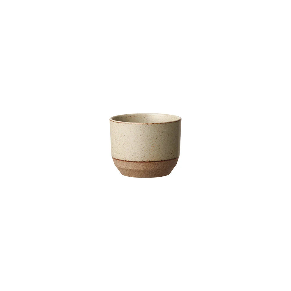 Ceramic cup with a beige exterior and brown base on a white background