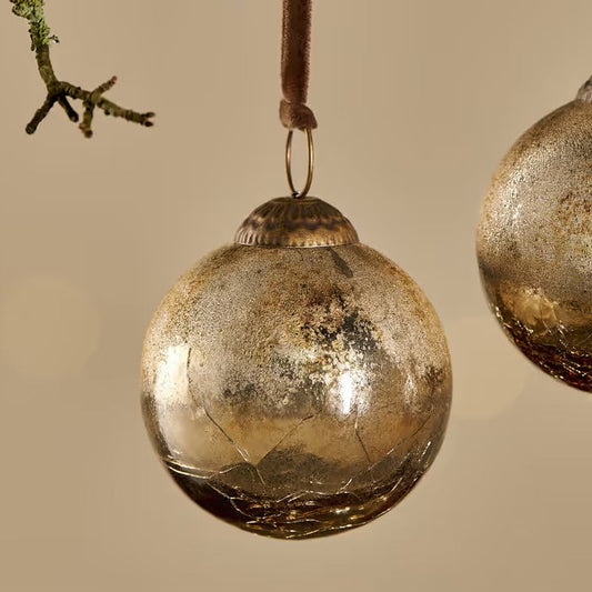 nkuku Gold Crackle Konara bauble gold glass ornaments hanging against a beige background
