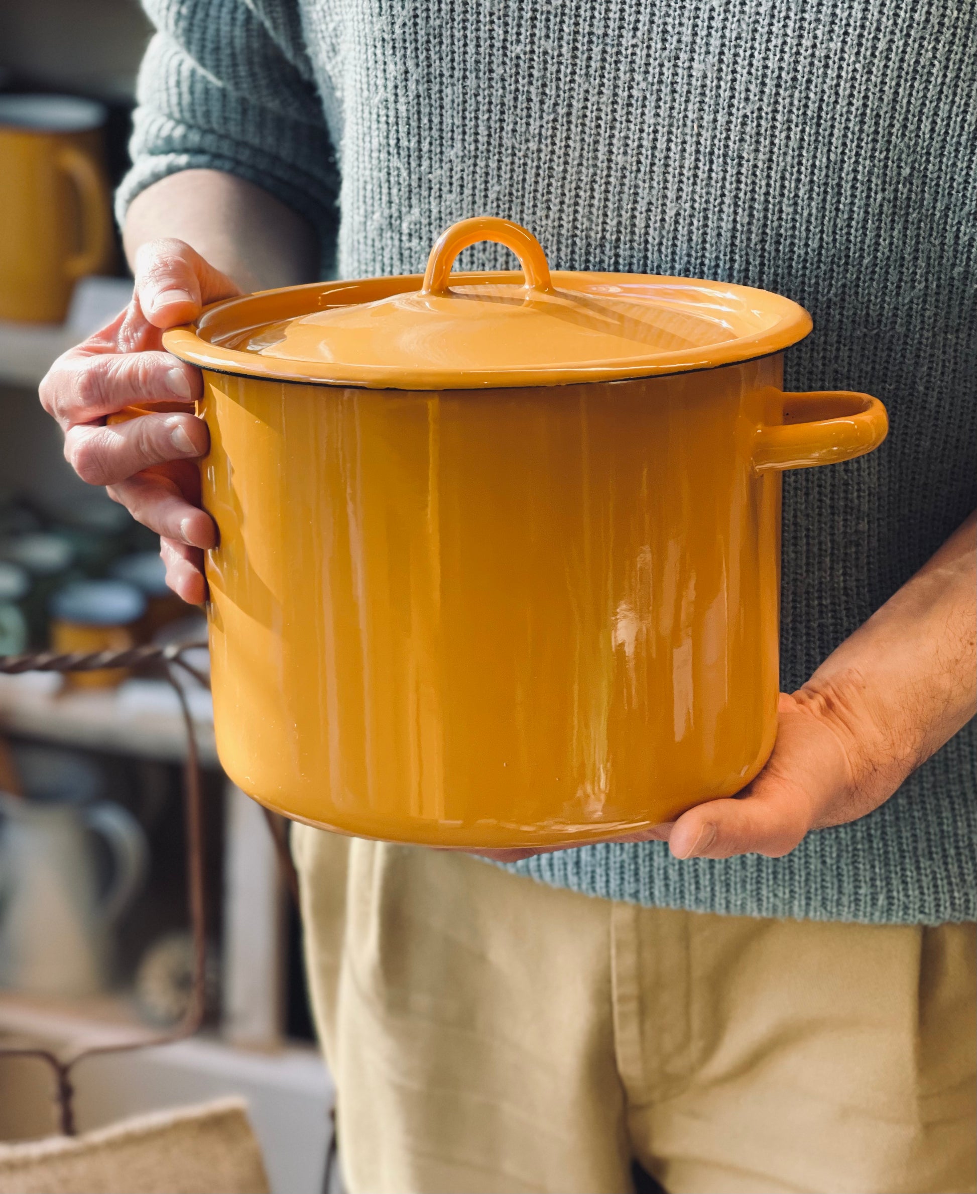 Person holding a yellow cooking cook pot with a lid in a home setting Ukraine made