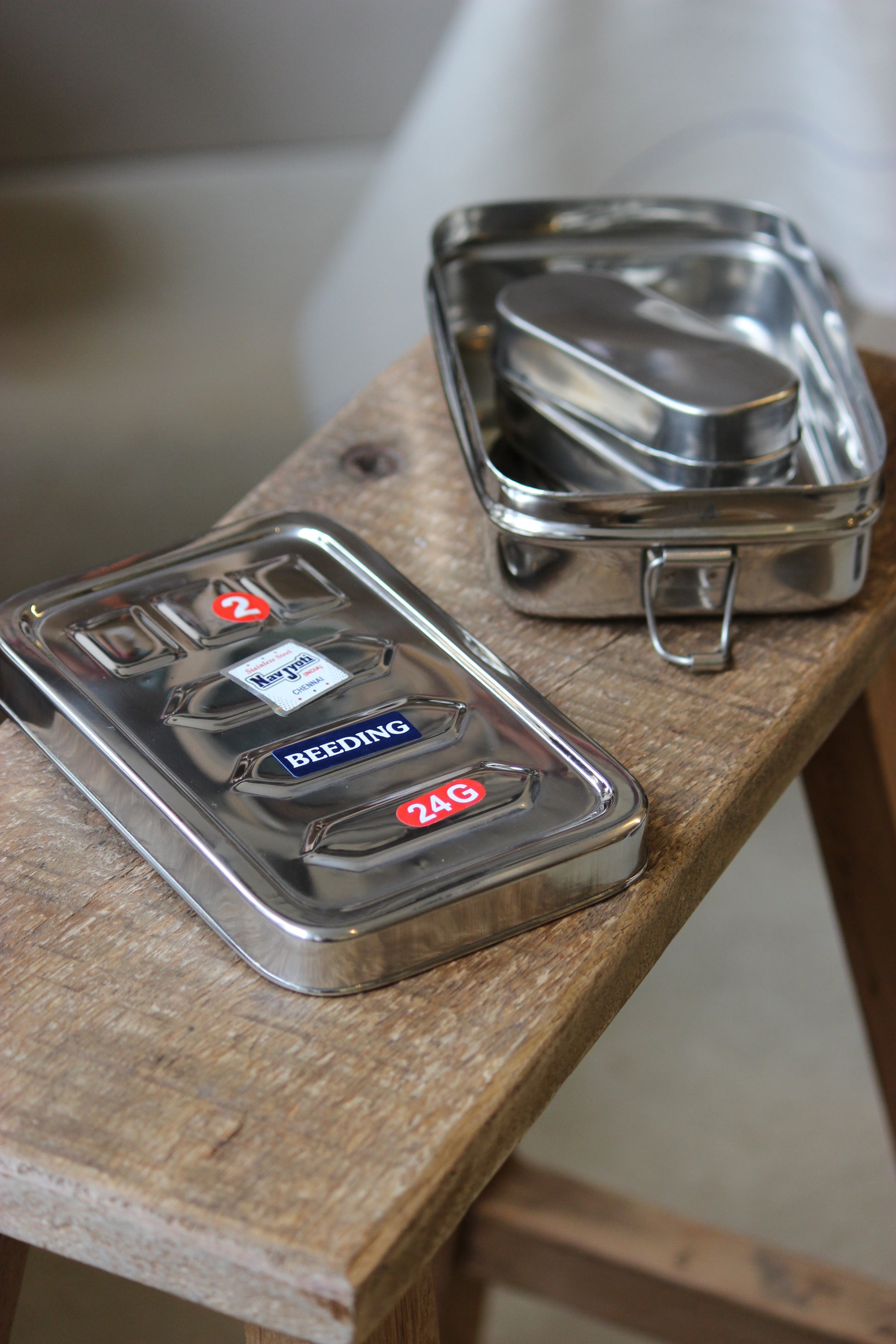 Metallic hinges on a wooden surface with visible brand logos.