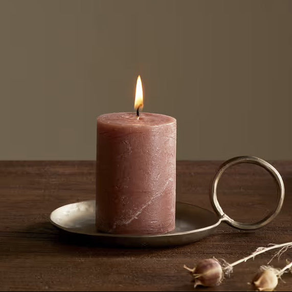Rust candle soy blend from nkuku on a wooden table with a glass and bowl in the background