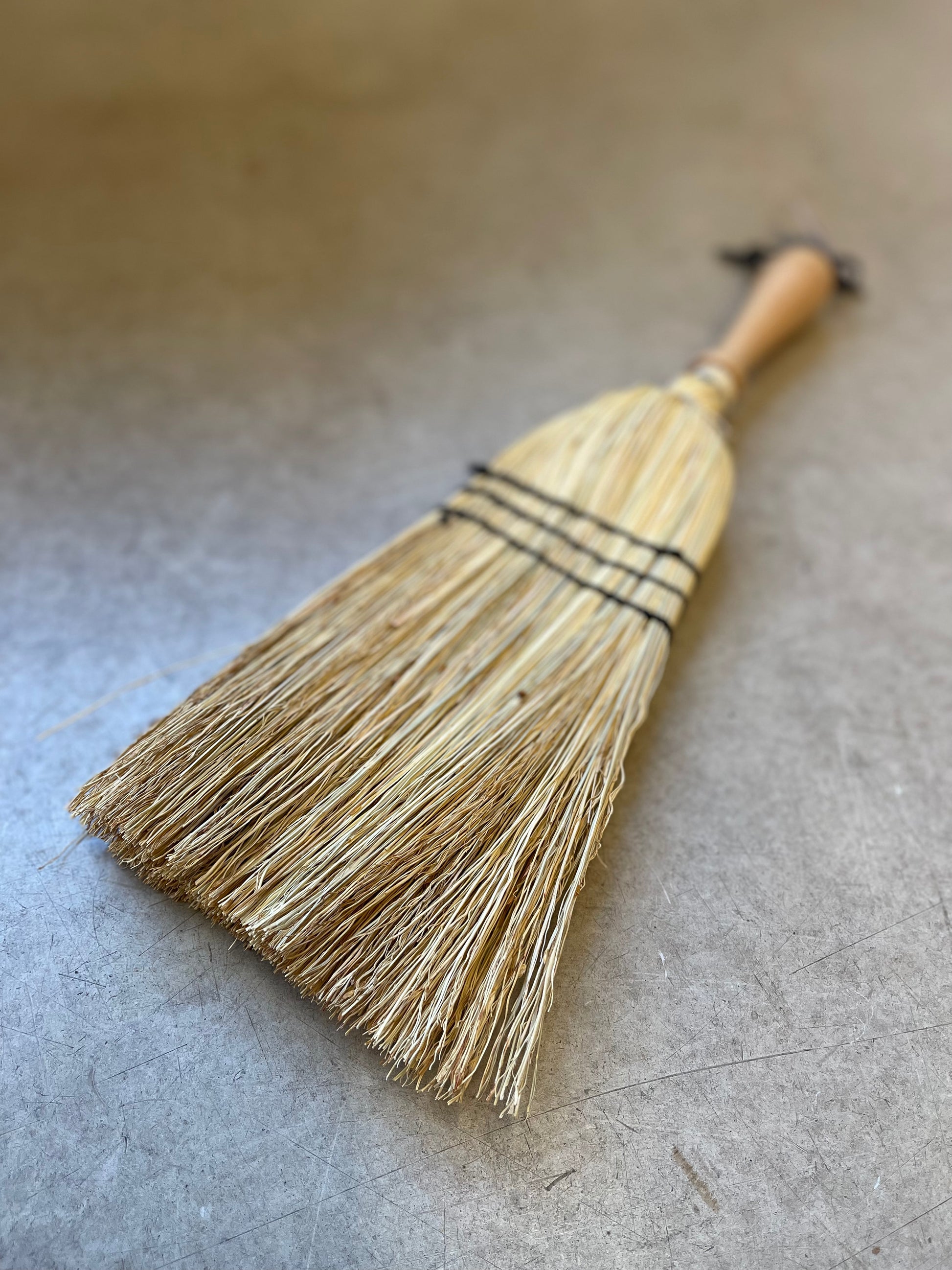Crafted from oiled beechwood and rice straw, this hand brush is ideal for indoor and outdoor use. Its non-absorbent properties make it perfect for sweeping up car mats and other surfaces. Measuring at 43cm, this is a smaller handheld brush designed in the shape of a broom. Please note that it is not a full-size broom.
