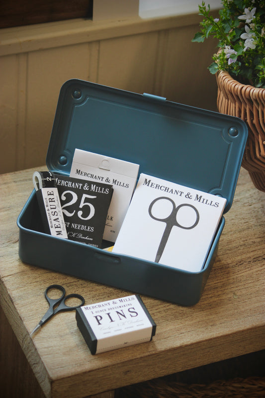Collection of Merchant & Mills sewing supplies in a TOYO Steel T-190 Trunk Tool Box in Duck Blue on a wooden surface.