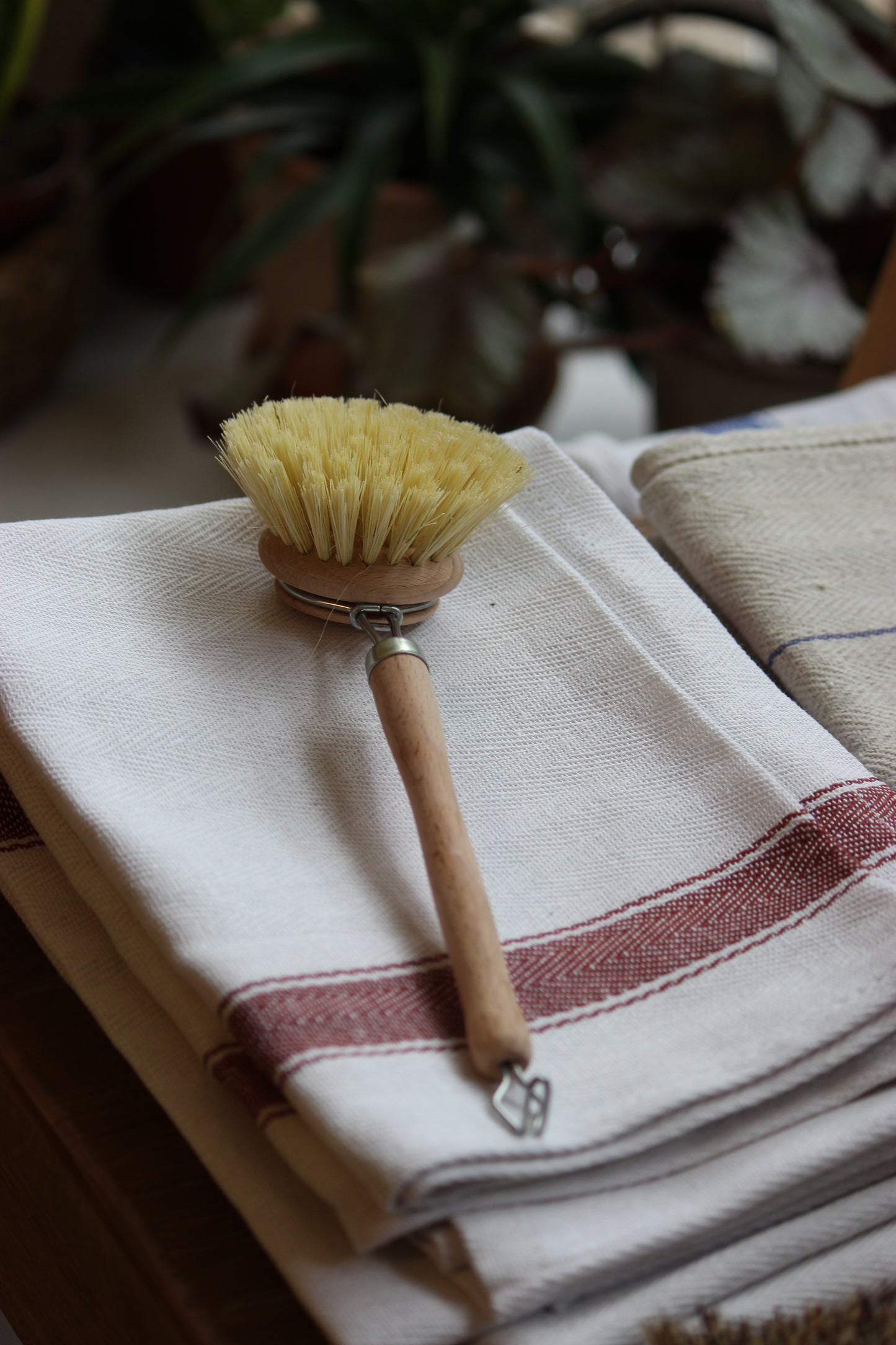 Cleaning brush with wooden handle on a towel