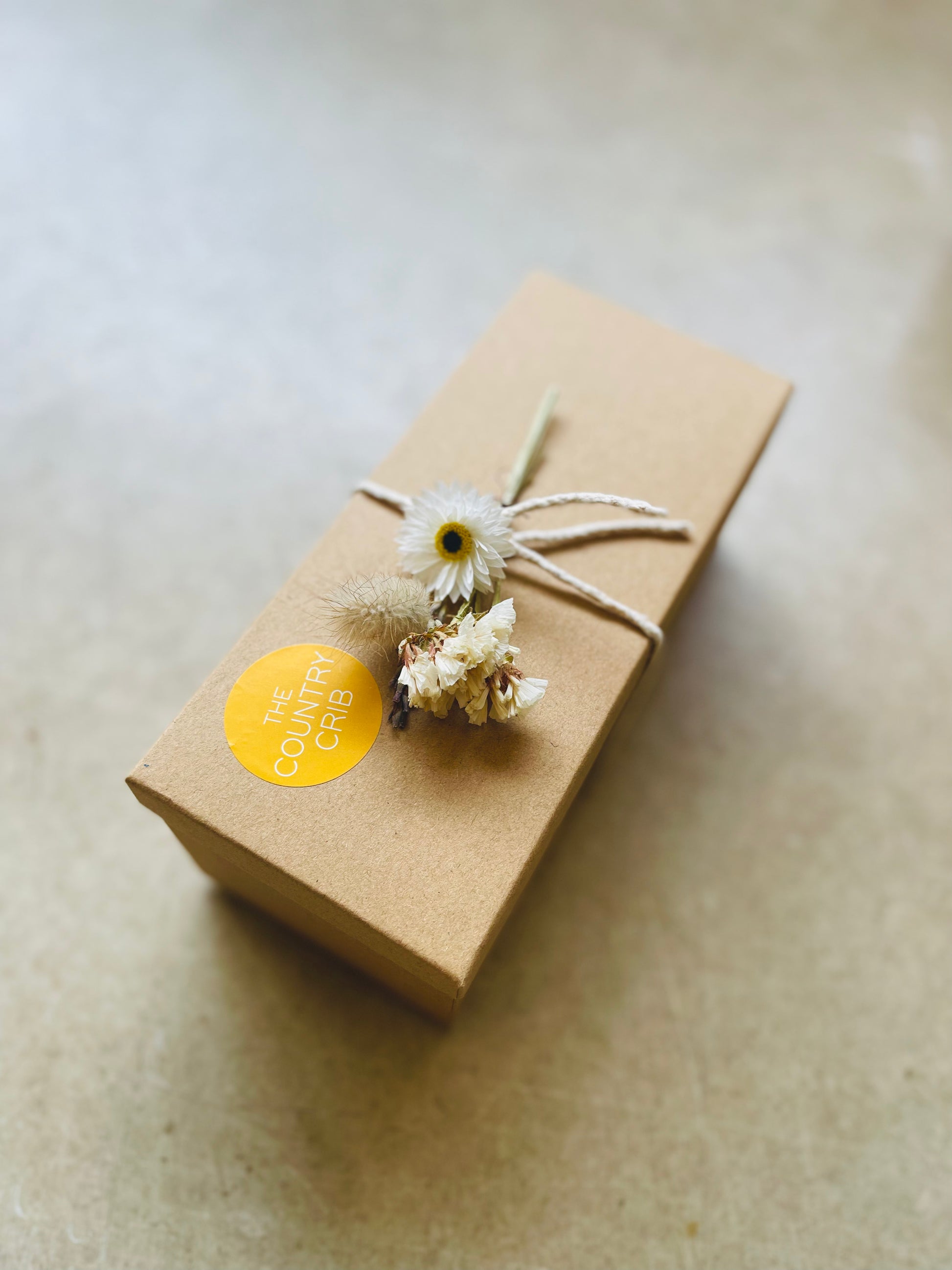 The Country Crib Gift Box, sustainable, no plastic, kraft paper filling and presented with cotton twine and British-grown dried flower spray