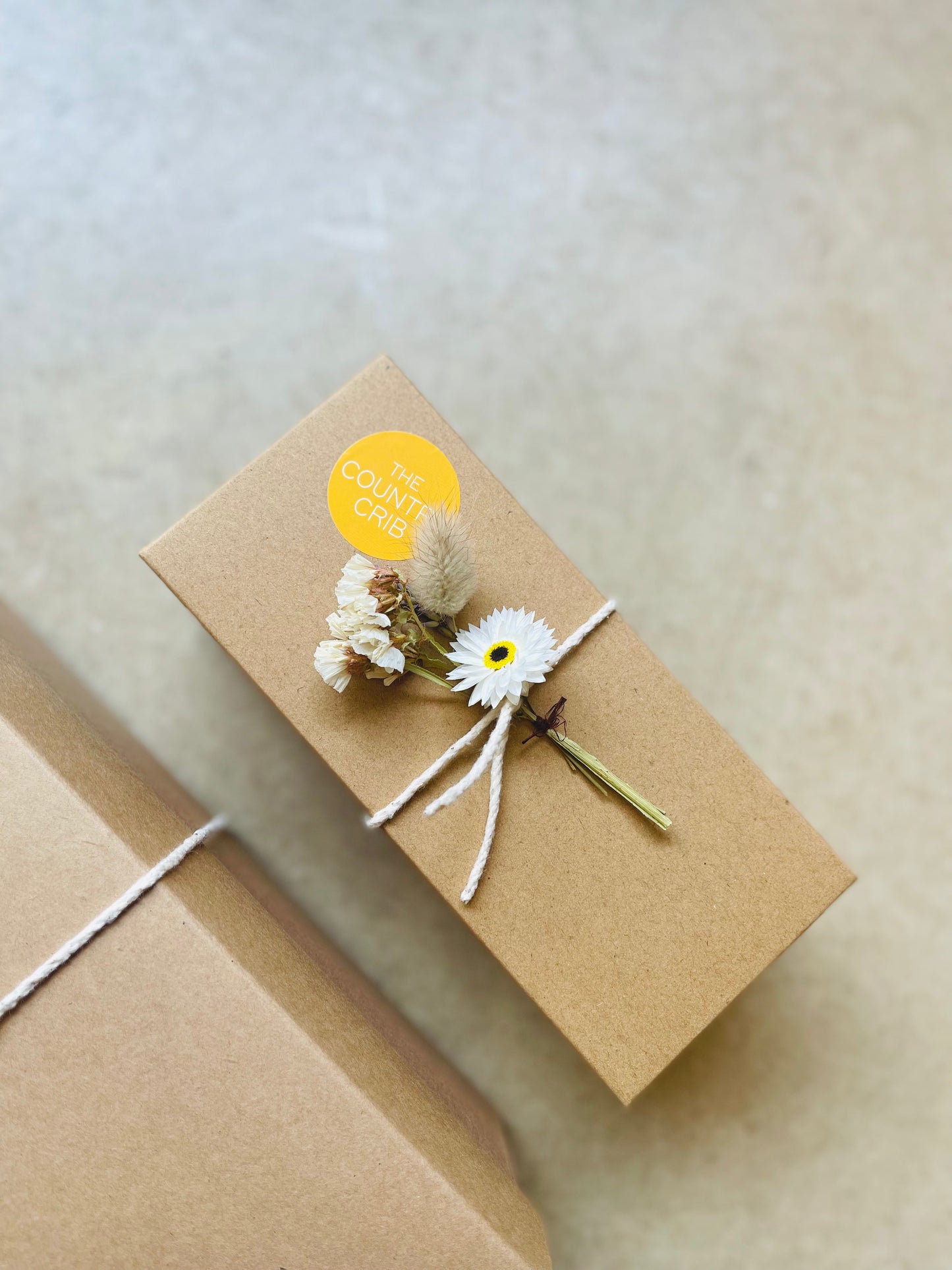 The Country Crib Gift Box, sustainable, no plastic, kraft paper filling and presented with cotton twine and British-grown dried flower spray