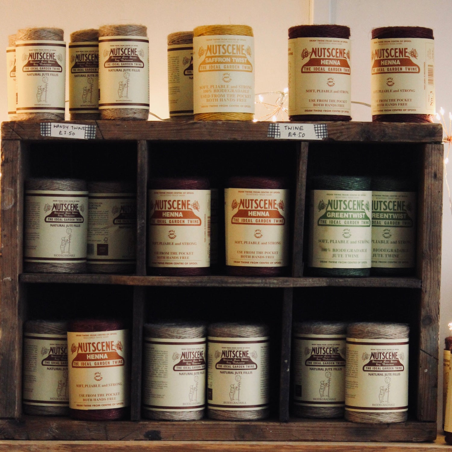 Wooden shelf with various Nutscene jute twines jars and bottles on a wooden surface in The Country Crib shop.