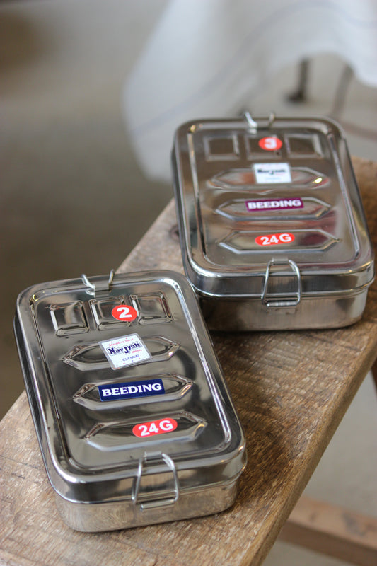 Two metal lunchboxes with visible brand logos on a wooden surface.
