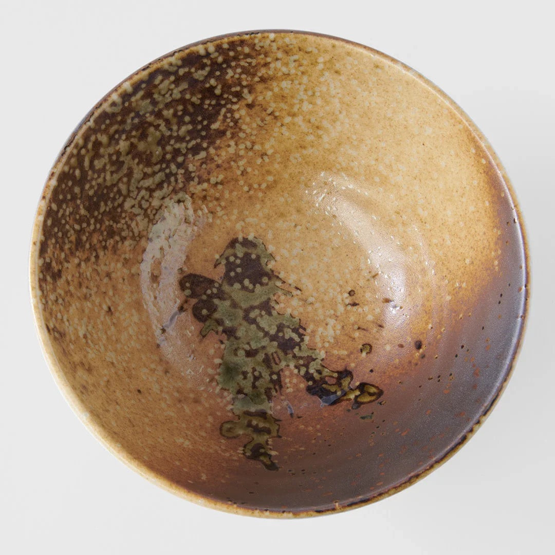 A handmade ceramic bowl with a rustic, hand-painted glaze featuring a gradient from dark brown to warm beige with a green and brown abstract pattern in the center, shown from a top-down view on a light gray background. Wabi Sabi Udon Bowl 19cm made in Japan 
