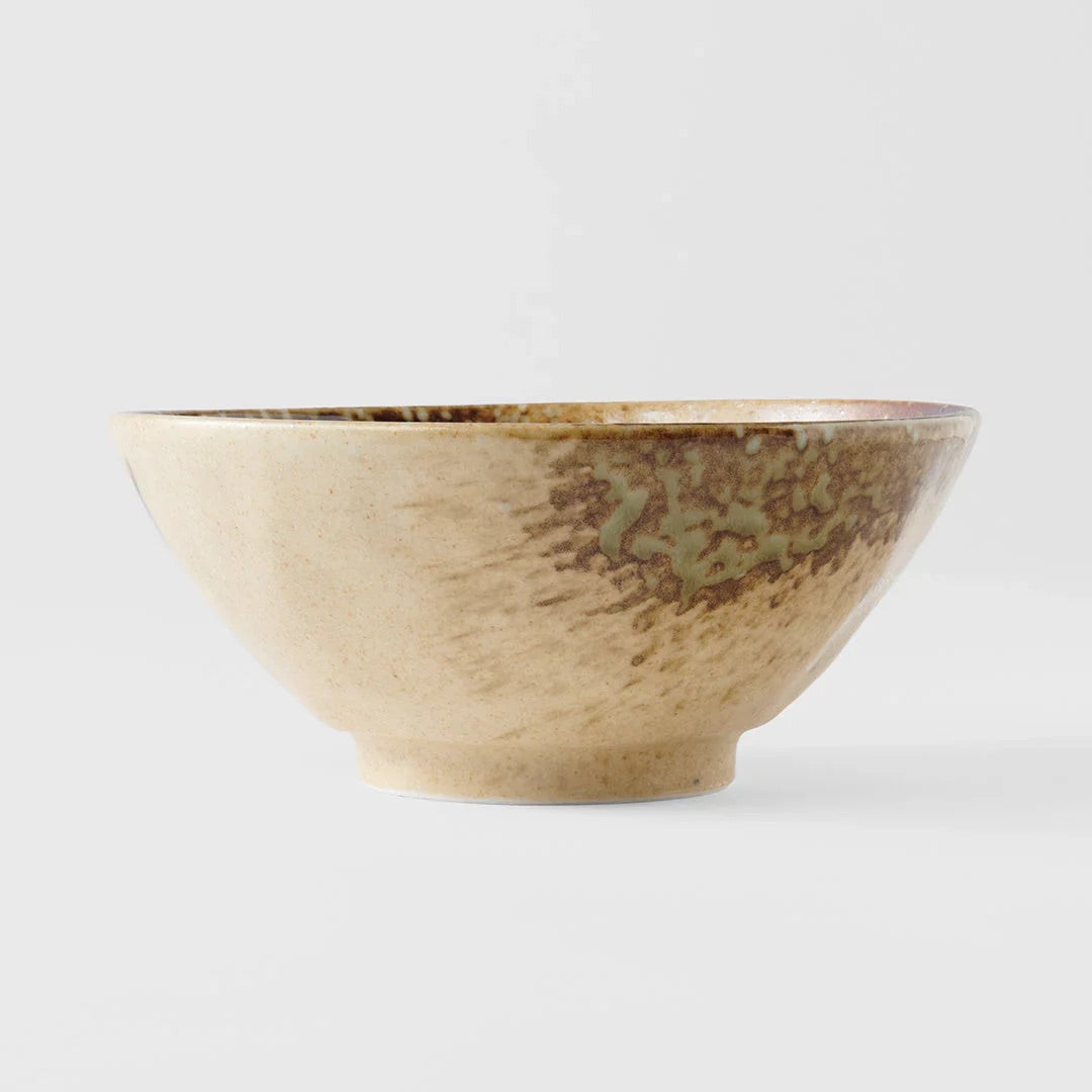 A handmade ceramic bowl with a textured beige and brown glaze, featuring a subtle greenish-brown pattern on the upper right side, set against a plain light gray background.Wabi Sabi Udon Bowl 19cm made in Japan 