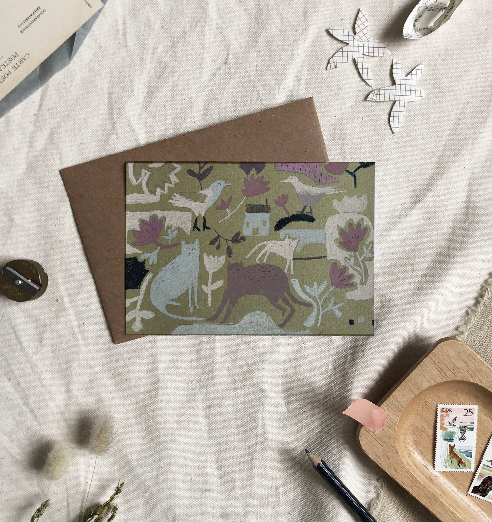 Greeting card with animal pattern on a textured surface with stationery items.
