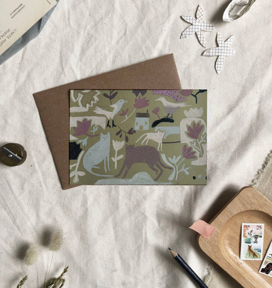 Greeting card with animal pattern on a textured surface with stationery items.