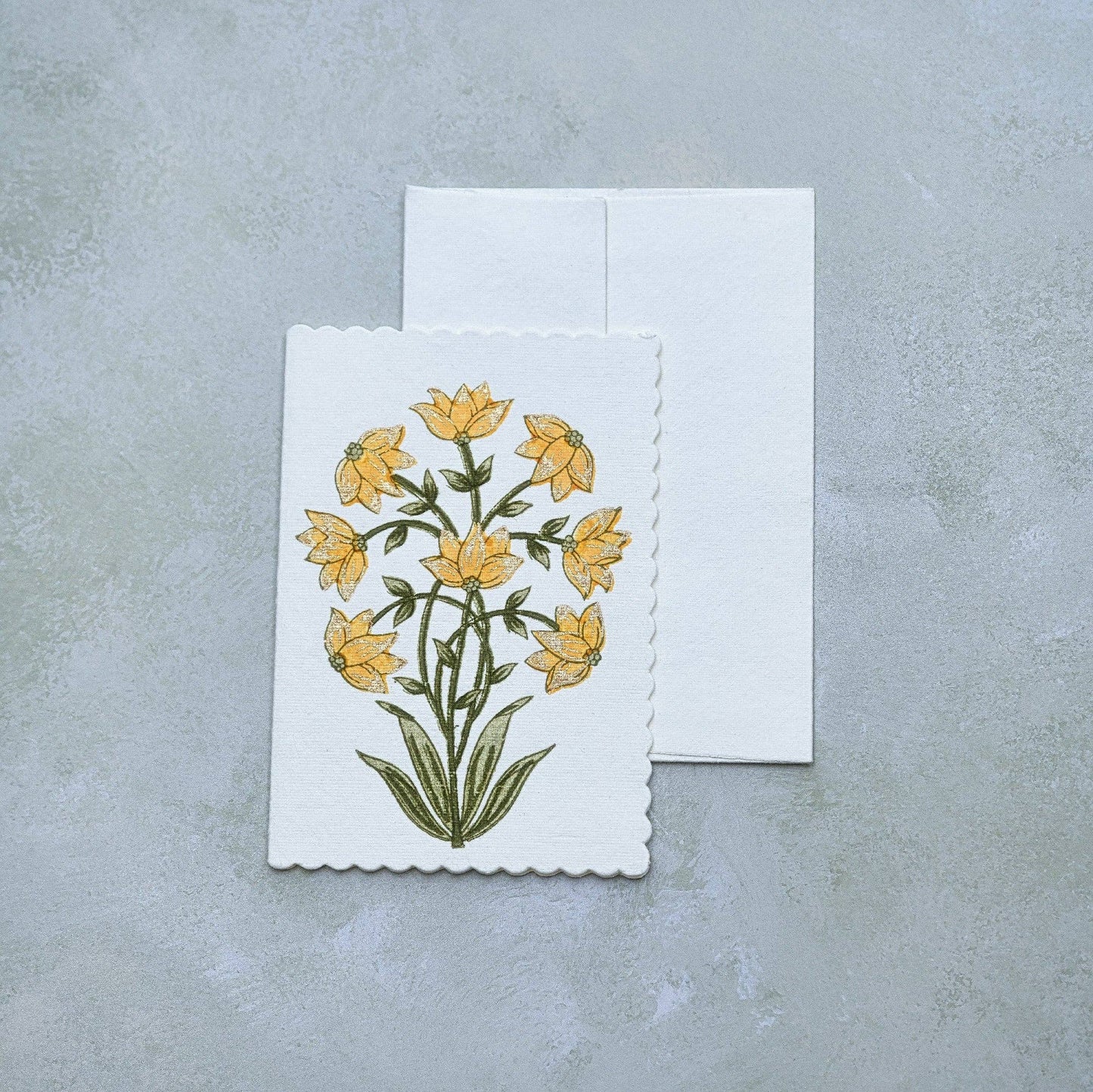 Greeting card with yellow floral design on a gray surface