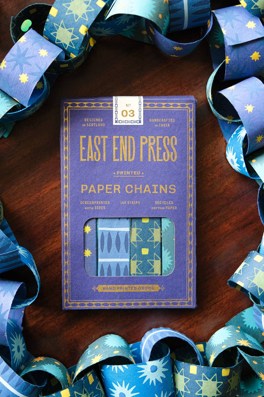 Pack of East End Press paper chains on a wooden surface with decorative ribbons.