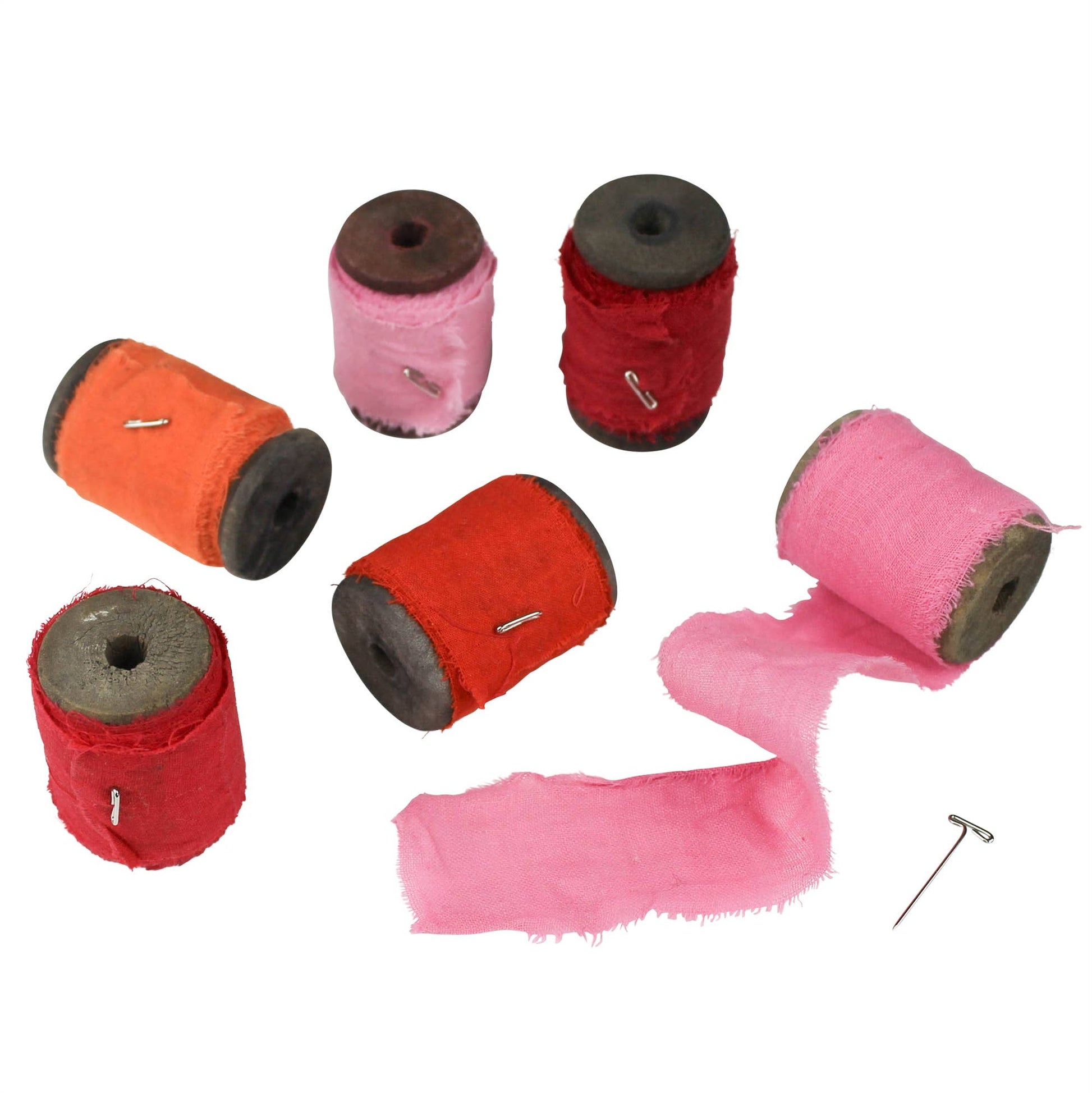 Set of colorful spools of fabric with a needle on a white background