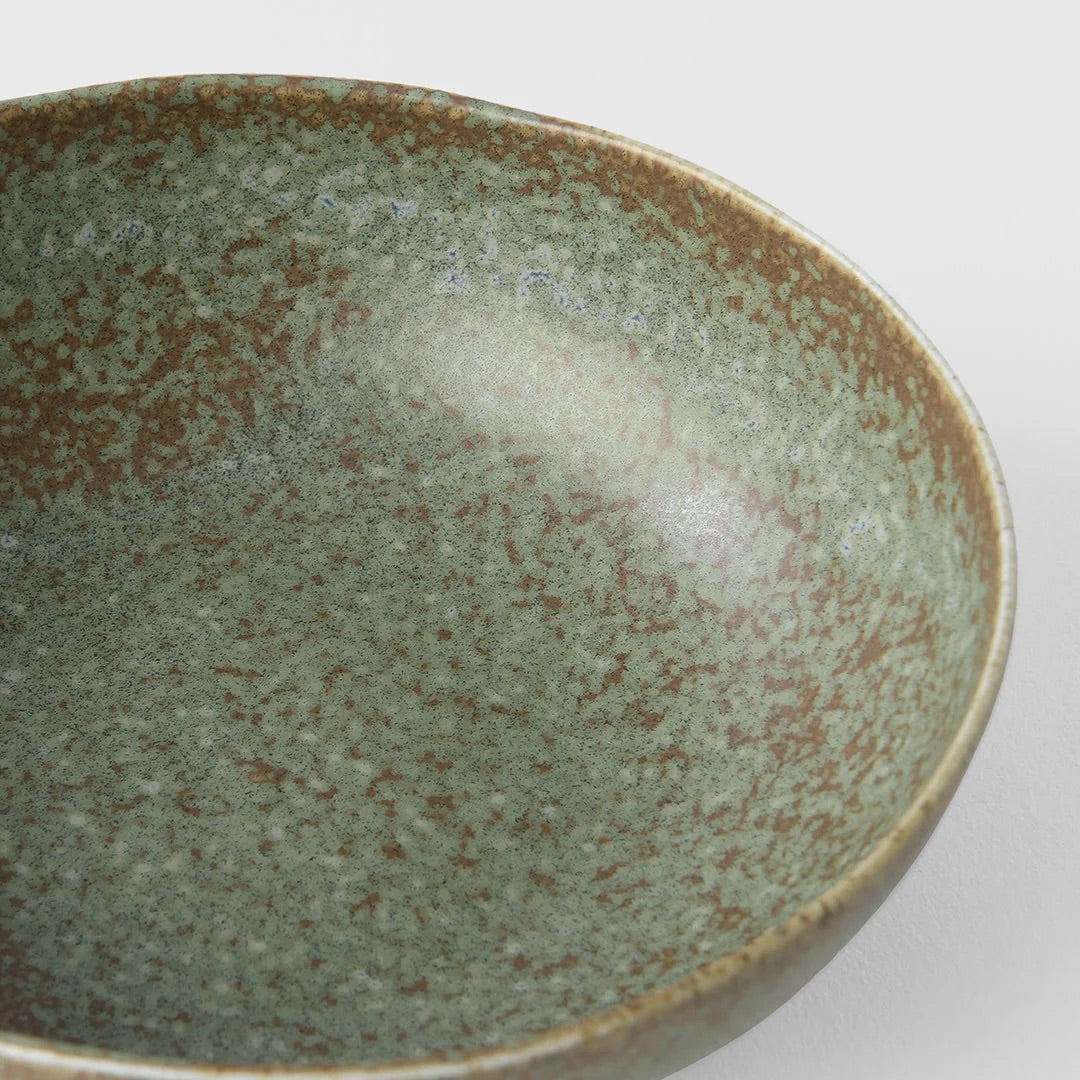 Green ceramic bowl with speckled texture on a white background Green fade bowl from Japan 