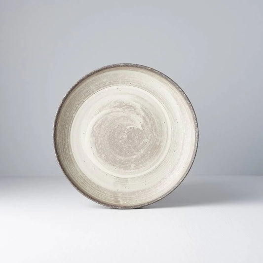 Round ceramic plate with textured surface on a light gray background