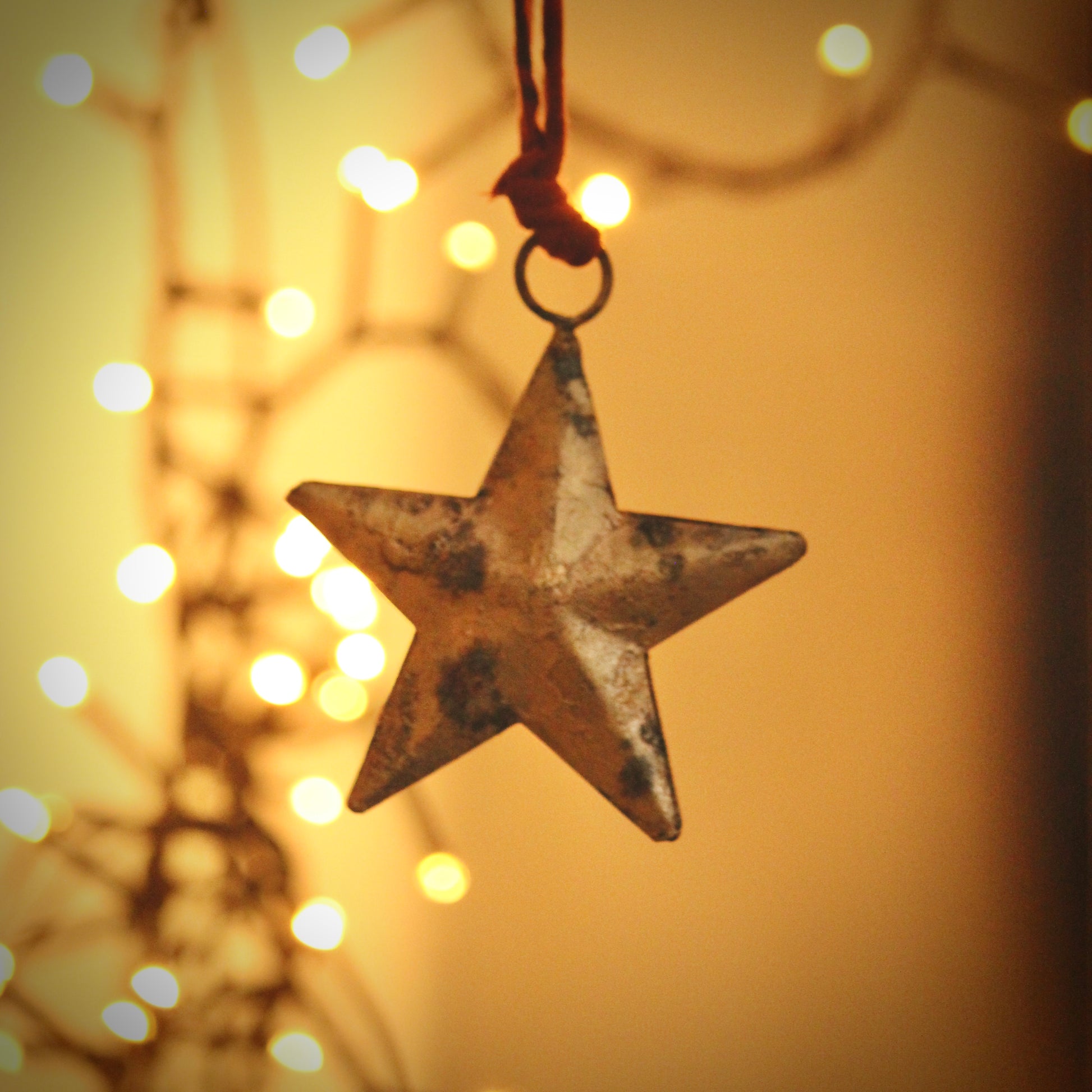 nkuku Rohani Star Bauble Star-shaped ornaments hanging against a warm glow in the background