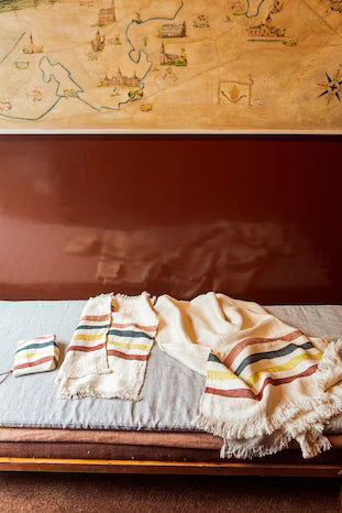 Textile with striped patterns draped over a surface, with a map in the background